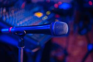 microphone stands in the holder at a concert in the restaurant. Close-up. Blurred blue background photo