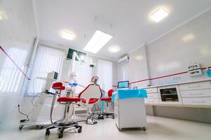 Dentistry, medicine, medical equipment and stomatology concept - interior of new modern dental clinic office with chair. photo