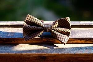 Bow tie on wooden background. Classic groom accessories photo