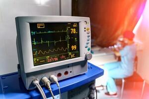 Modern medical monitor displaying statistics of patient. Medical worker working in quarantine. photo