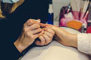 niña pintar uñas en el salón de manicura, de cerca foto