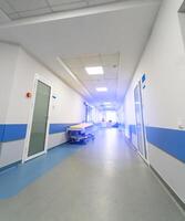 moderno vacío hospital corredor con ligero paredes nuevo largo emergencia clínica salón. foto