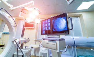 operating room with X-ray medical scan. real modern operating theater with working equipment, lights and computers. photo