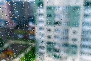 Natural water drop on glass. Selective focus. Rainy city background photo