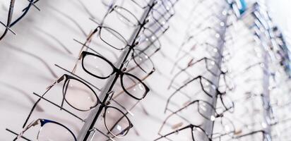 Glasses on display on wall in store. Showcase with spectacles in modern ophthalmic store. photo