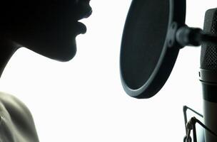 Portrait of young woman recording a song in a professional studio. Black and White. photo