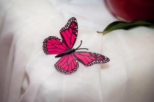 Table setting decoration at a gala dinner corporate formal event banquet pink butterflies on the table cloth. Closeup. photo