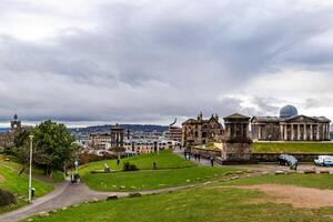 Panoramic view of a historic cityscape with green park space under a cloudy sky. photo