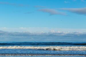 Serene beach landscape with gentle waves and clear blue sky. photo