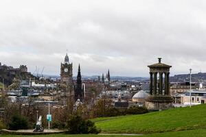 panorámico ver de Edimburgo horizonte con histórico monumentos y nublado cielo, desde Calton colina, Escocia. foto