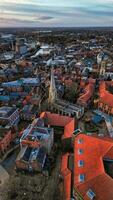 Aerial view of a historic town at dusk with prominent church spire and terracotta rooftops against a moody sky in York, North Yorkshire photo