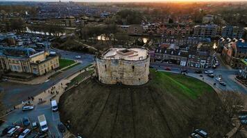 Aerial view of a historic circular stone fortress at dusk, with surrounding urban landscape and sunset sky in York, North Yorkshire photo