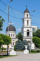 Orthodox church with bell tower on a sunny day, surrounded by greenery in an urban setting in Chisinau, Moldova. photo