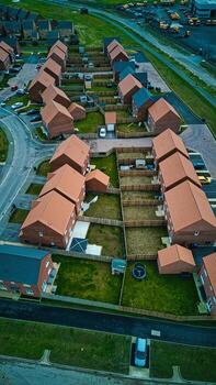 Aerial view of a suburban neighborhood with rows of houses and gardens at dusk. photo