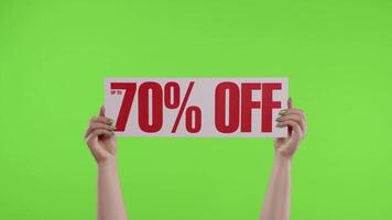 70 Percent Off advertisement inscription on paper sheet in womans hands on chroma key. Slow motion video