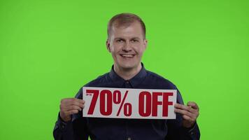 Smiling man showing Up To 70 percent Off inscriptions signs, rejoicing good discounts, low prices video