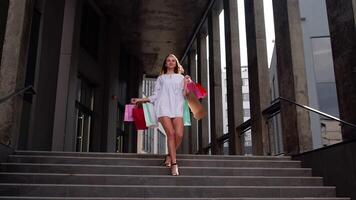 Attractive girl walking from centre mall with shopping bags, happy with purchase on Black Friday video