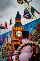 Festive fairground scene with a Big Ben replica, Ferris wheel, and colorful decorations under a cloudy sky. photo