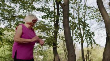 Senior Sport Läufer Frau mit Clever Uhr tippen Touch-Screen, Verfolgung Ergebnis. Fitness trainieren video