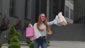 niña levantamiento compras bolsas, mirando satisfecho con compra, disfrutando descuentos en negro viernes video