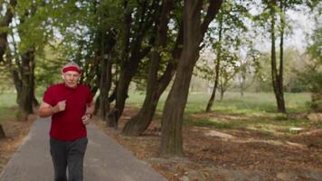 Elderly sport man stops after running, using smart watch, checking heart rate during fitness video