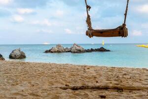 View of the beach, sea, beautiful rocks during the day and swings at the beach. photo