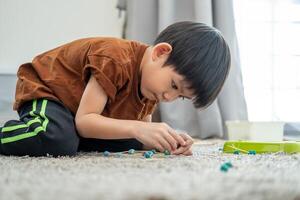 Asian boy playing with plasticine in the room photo