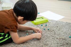 Asian boy playing with plasticine in the room photo