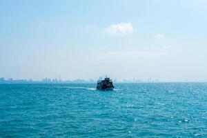 Seascape with passenger ships coming to the pier, back view of Pattaya city, Thailand photo