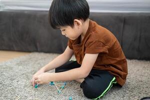 Asian boy playing with plasticine in the room photo