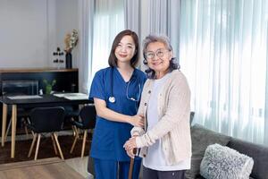 Senior woman got medical service visit from caregiver nurse at home while practice using walking cane or stick after knee surgery photo