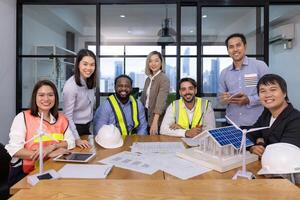 Team of architecture and engineer are discussing and brainstorming on floor plan over clean energy and power saving house design using solar panel for green industry and futuristic home development photo