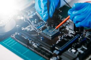 The technician is putting the CPU on the socket of the computer motherboard. electronic engineering electronic repair, electronics measuring and testing, repair photo