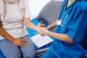 Doctor in white suit take notes while discussing and Asian elderly, woman patient who lying on bed with receiving saline solution photo