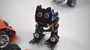 Dancing robot cat from a DIY children's construction set. Fundamentals of robotics at school. A toy made from circuit boards, microcircuits and batteries. Ukraine, Kyiv - December 16, 2023. video