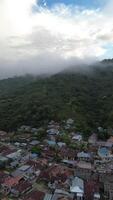 vertical aéreo imágenes de niebla en el montañas después tarde lluvia en gorontalo provincia, Indonesia video