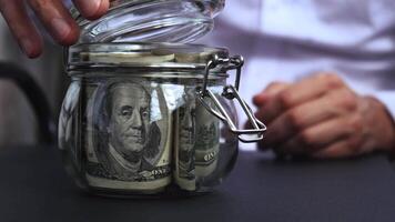 Dollar Banknote Saving Money In Glass Jar. Unrecognizable man Moderate Consumption And Economy Collecting Money Tips Business Finance footage video