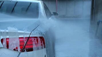 Washing luxury silver car on touchless car wash. Washing sedan car with foam self-service and high pressure water. Cleaning the details of car. Cleanliness and order in urban environment video