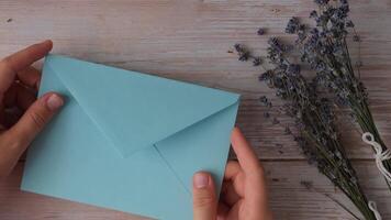 SELF CARE COMES FIRST text on supportive message paper note reminder from blue envelope. Flat lay composition dry lavender flowers. Concept of inner happiness, slowing-down digital detox personal fulfillment. Top view video