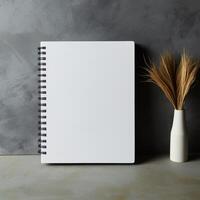 ai generado pulcro sencillez blanco cuaderno en un Frío, gris hormigón antecedentes para social medios de comunicación enviar Talla foto