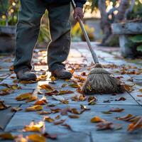 AI generated Diligent man with broom tidies cement patio, leaves dancing away For Social Media Post Size photo