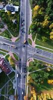 vertical accelerated video 8x aerial view above at crossroads on road junction with heavy traffic in city