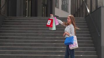 Girl showing Black Friday inscription on shopping bags, smiling, satisfied with low prices purchases video