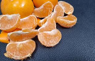 oranges stacked on black leather photo