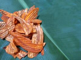 Picture of dried banana slices placed on banana leaves. photo