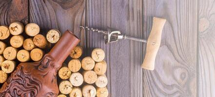 Bottle of wine with corks on wooden table background. on soft sunlight photo