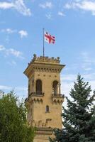 Georgia bandera en el techo de un antiguo torre en contra el claro azul cielo foto