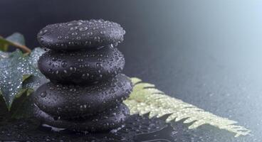 Stacked wet spa stone with green leaf. selective focus.tone image on sunlight photo