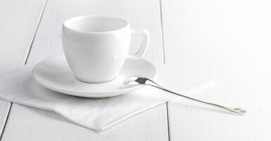 blanco vacío taza de café en un blanco servilleta. cerca arriba foto