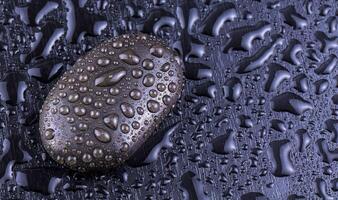 Spa stones on black background with water. Spa concept. photo